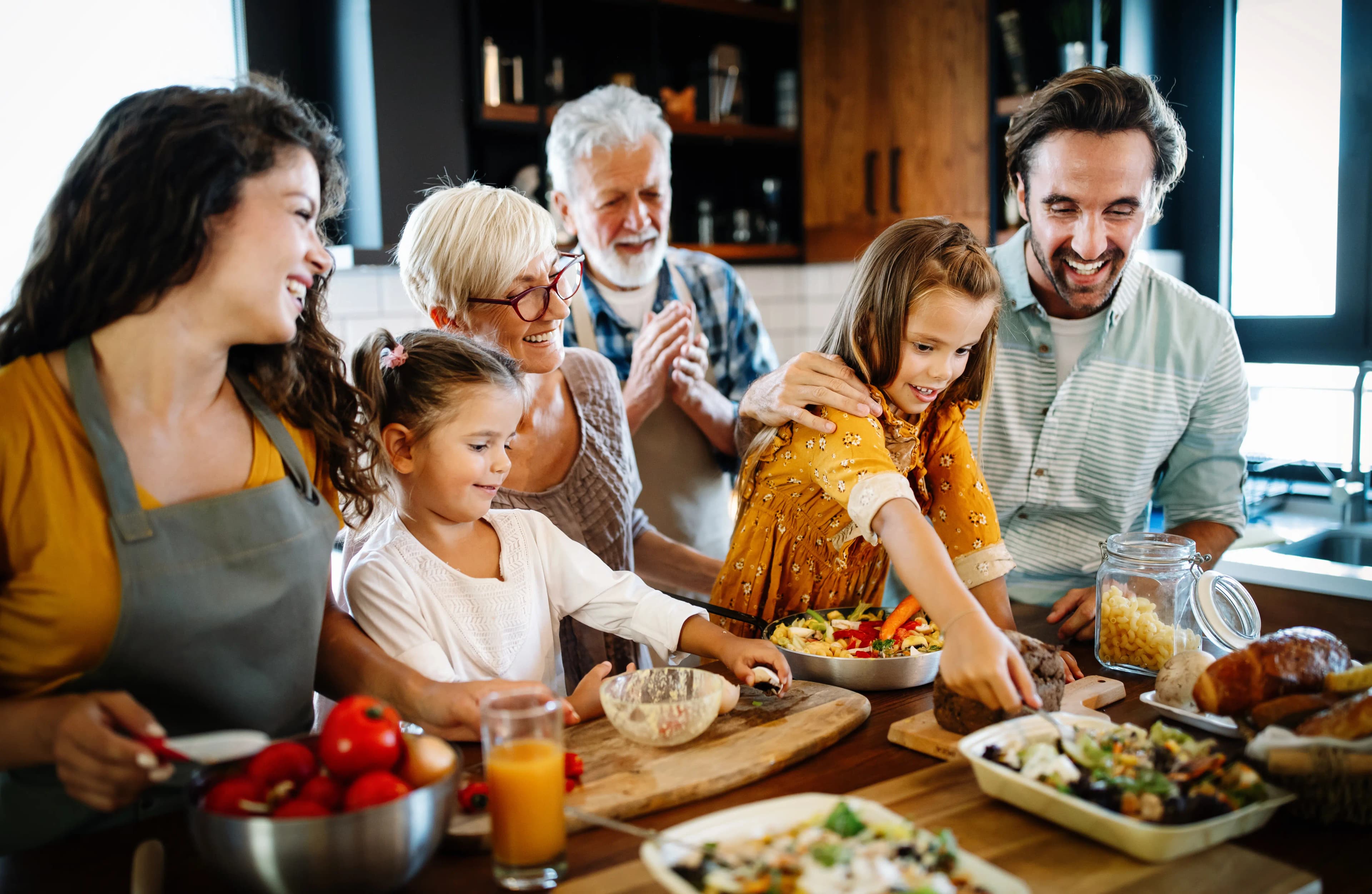 Multigenerational family of grandparents, parents and children sharing a meal together at the table