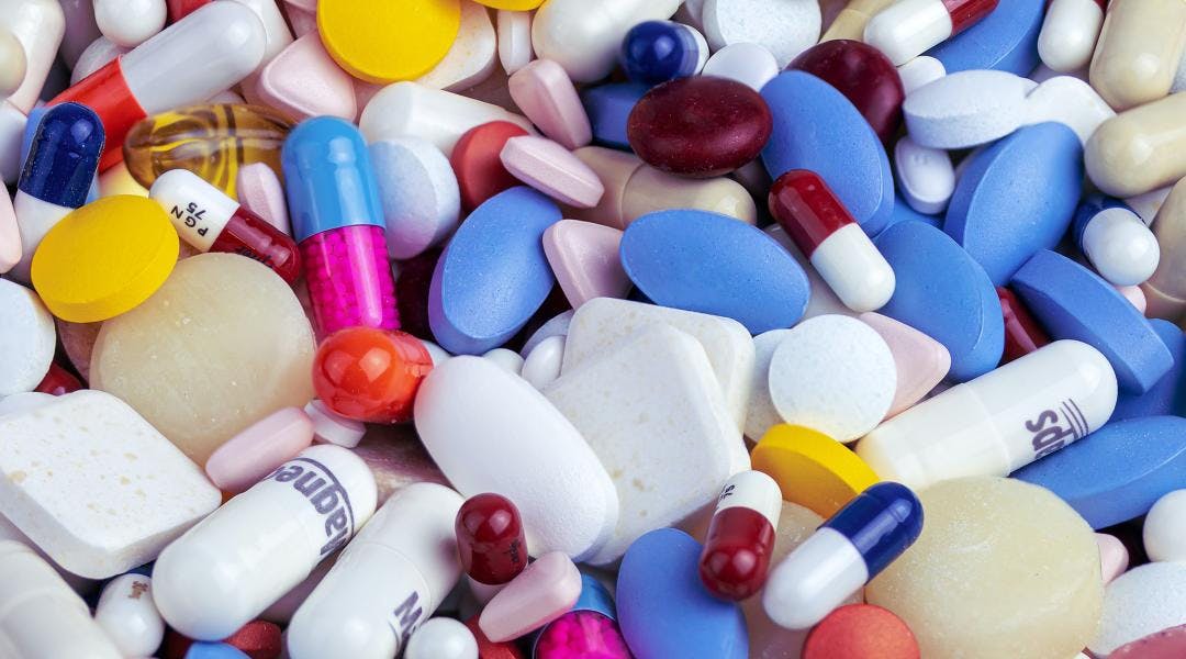 A close-up of several different kinds of brightly colored medication pills and capsules.